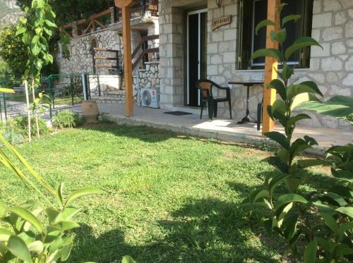 a yard with a table and a chair in front of a house at Sivros Stone Cottages in Sívros