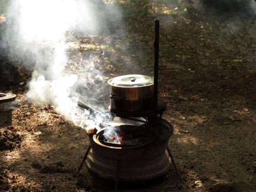 a grill with a pot on top of it with smoke at STF Nyrups Naturhotell in Höör