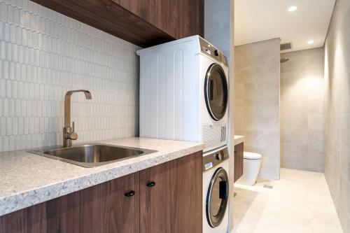 cocina con fregadero, lavadora y secadora en Terra Suite - Central Dunsborough Luxury Apartment, en Dunsborough