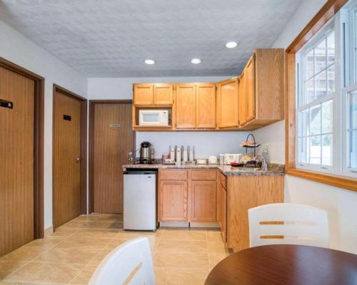 a kitchen with wooden cabinets and a white refrigerator at Econo Lodge in Saint Albans