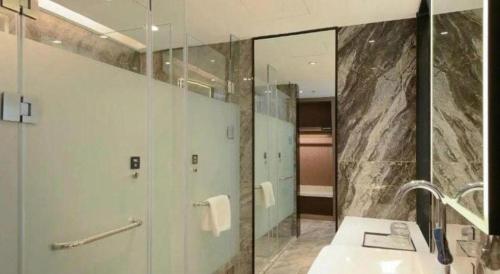 a bathroom with a shower and a sink and a mirror at Nanning Prince Hotel in Nanning
