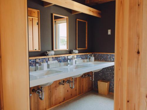 a bathroom with three sinks and a window at Cider Barn &more in Iida