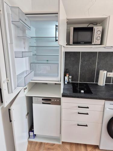 a kitchen with white cabinets and a microwave at 2-Zimmer Wohnung 3 - Apartments am Schloss in Oberschleißheim