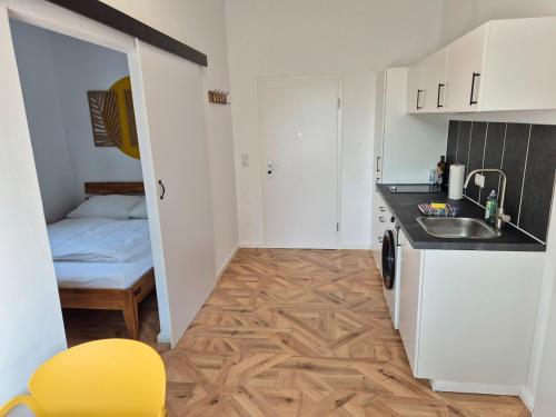 a small kitchen with a sink and a bed at 2-Zimmer Wohnung 3 - Apartments am Schloss in Oberschleißheim