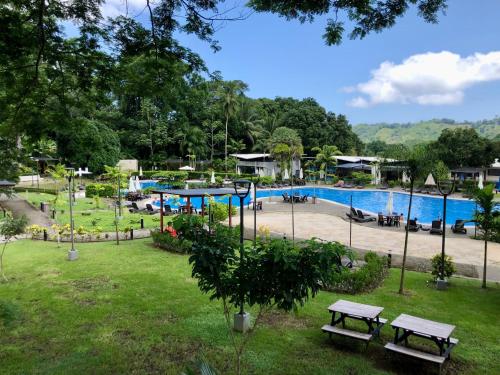 un parque con piscina y mesas de picnic en Near from Beach- Cozy Herradura Tropical home, en Herradura