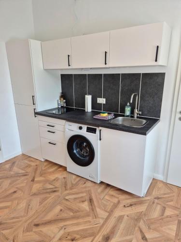a kitchen with a washing machine and a sink at 2-Zimmer Wohnung 3 - Apartments am Schloss in Oberschleißheim