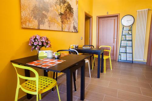 une salle à manger avec deux tables et des chaises jaunes dans l'établissement La Casermina, à Pise