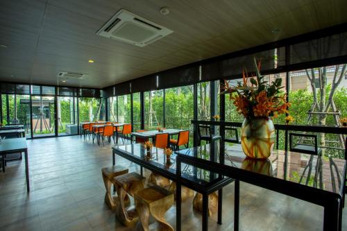 a dining room with a vase of flowers on a table at Hyde Park Chiangmai in Chiang Mai
