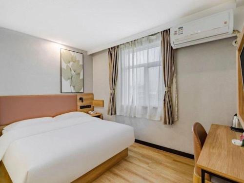 a hotel room with a bed and a window at GreenTree Inn Anqing Renmin Road Commercial Street Express Hotel in Anqing