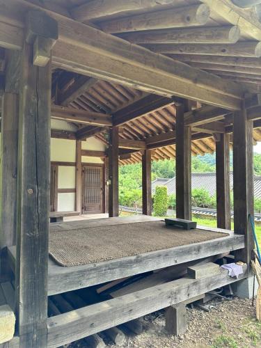 a wooden pavilion with a bed on a platform at Korean Traditional House - Chungnokdang in Boseong