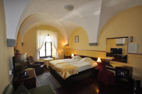 a hotel room with a bed and a window at Hotel Barbakan in Levoča