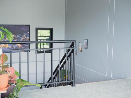 eine Treppe mit Geländer und Fenster in der Unterkunft Borrii House โบ ลี่ เฮาท์ in Layan Beach