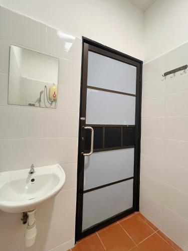 a bathroom with a sink and a mirror and a door at Quee Hotel in George Town