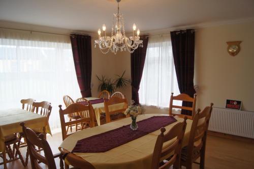 uma sala de jantar com uma mesa e cadeiras e um lustre em Southwind B&B em Spanish Point