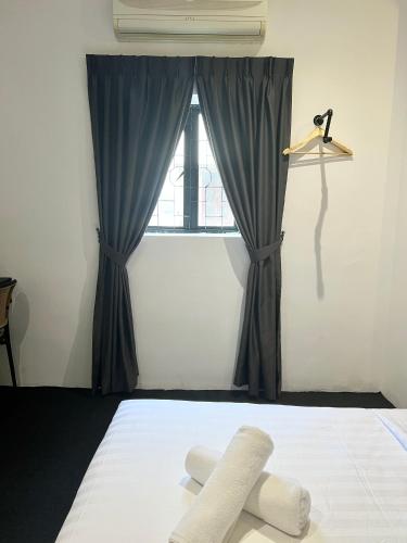 a bedroom with a bed with a window at Quee Hotel in George Town