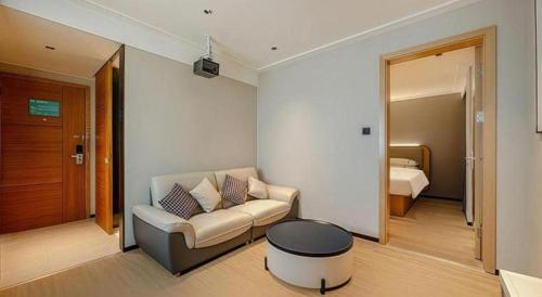 a living room with a couch and a bed at City Comfort Inn Beihai RT-Mart High Speed Railway Station in Beihai