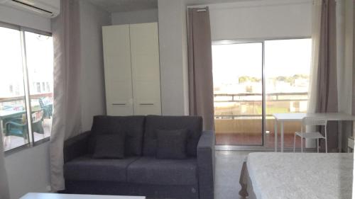 a bedroom with a couch and a bed and a table at Hotel Carlos I in Torremolinos