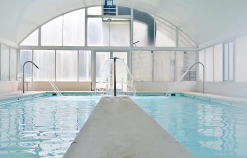 a large swimming pool with a large window at Hotel Termas de Liérganes in Liérganes