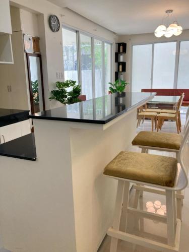a kitchen with a counter with stools and a table at House at the City Center in Tuguegarao City