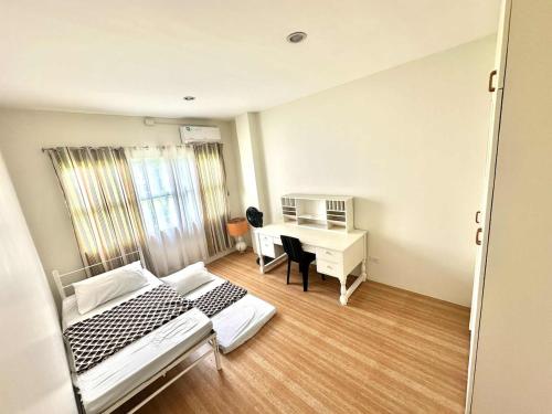 a bedroom with a bed and a desk in it at House at the City Center in Tuguegarao City