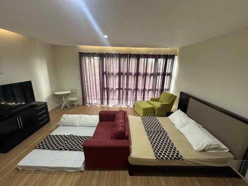 a room with a bed and a couch and a window at House at the City Center in Tuguegarao City
