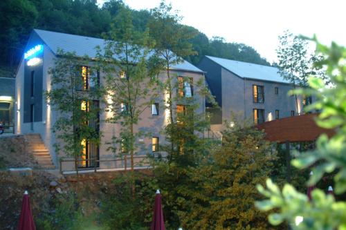 a large building with lights on in front of it at Hôtel Val de Poix- Logis Hôtel Restaurant in Saint-Hubert