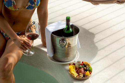 a woman holding a glass of wine and a bucket of food at Proud Phu Fah Muang Chiang Mai in Chiang Mai