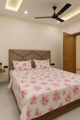 a bedroom with a large bed with pink flowers at Hotel Janki Nandan Palace in Vrindāvan