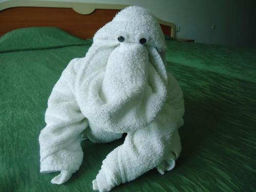 a white towel animal sitting on a bed at Guesthouse Ruskovi in Ravda
