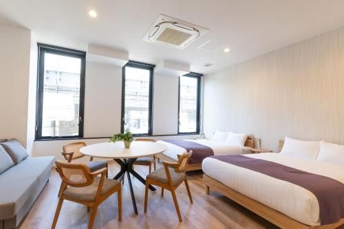 a hotel room with two beds and a table at BON Osaka Namba East in Osaka