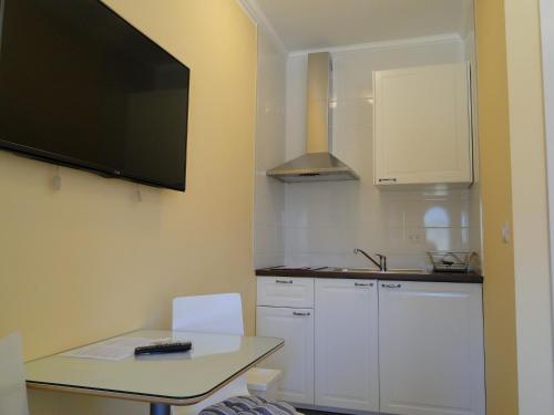 a small kitchen with a table and a tv on the wall at Villa Ester in Umag
