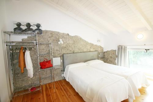 a bedroom with two beds and a stone wall at Villas San Roque Isla in Isla