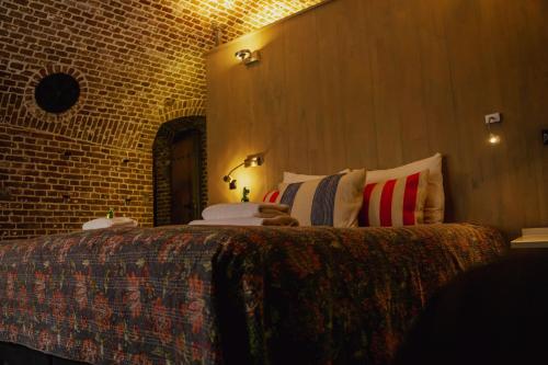 a bedroom with a large bed in a brick wall at Fort Vuren in Vuren