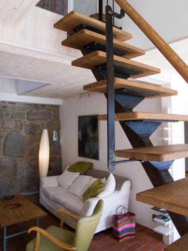 a living room with a spiral staircase in a house at Apan & Klyset in Simrishamn