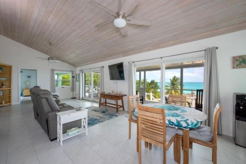 a living room with a dining room table and a view of the ocean at Ware-A-Dise - Newly Remodeled Home on Calm Caribbean home in South Palmetto Point