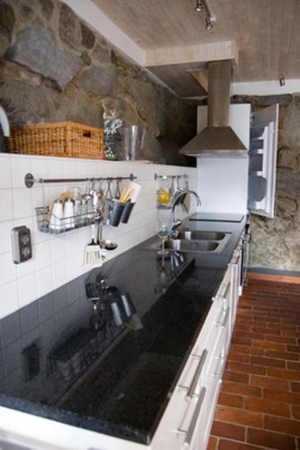 a kitchen with a sink and a stove at Apan & Klyset in Simrishamn