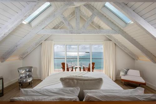a bedroom with a bed with a view of the ocean at Touch of Class Cottage - A Caribbean Beachfront Cottage cottage in Savannah Sound