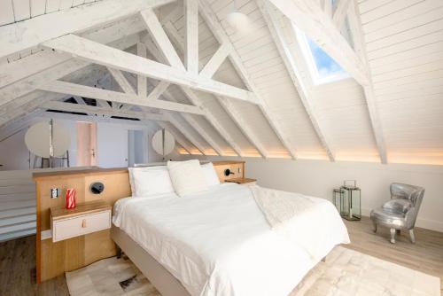 a bedroom with a large bed and a chair at Touch of Class Cottage - A Caribbean Beachfront Cottage cottage in Savannah Sound