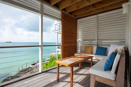a living room with a view of the ocean at Touch of Class Cottage - A Caribbean Beachfront Cottage cottage in Savannah Sound