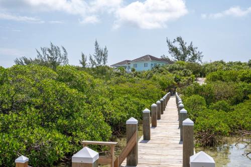 a wooden boardwalk leading to a house on the beach at Turtle Pointe - Lux New Windermere Home withPool, Boat Dock, Beach home in Savannah Sound
