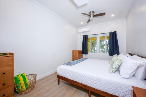 a bedroom with a bed and a ceiling fan at Laughing Bird 1BR #3 - Brand New Stylish Apartment, Pool, Beach condo in Colebrooke Dale