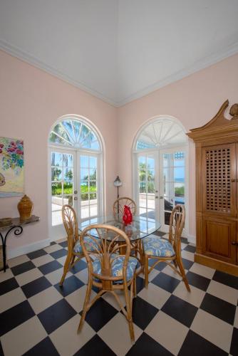a dining room with a table and chairs and windows at Coriolana home in Savannah Sound