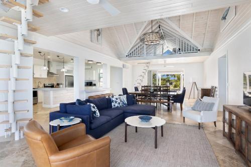 a living room with a blue couch and a table at Buttonwood Reserve Compound - Compound withBeach, Pool, Pickleball condo in James Cistern