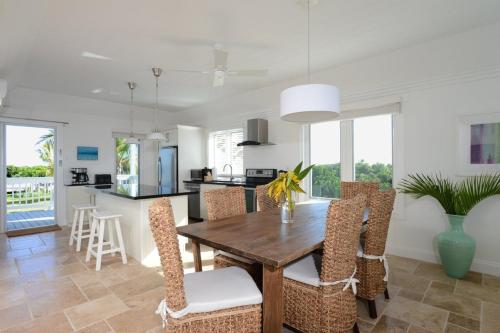 a kitchen and dining room with a wooden table and chairs at Buttonwood Reserve Compound - Compound withBeach, Pool, Pickleball condo in James Cistern