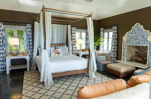 a bedroom with a canopy bed and a fireplace at Beehive Harbour Island, Luxury Dream World on the Bay, Private d home in Harbour Island