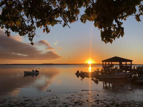 a sunset on a lake with boats in the water at Beehive Harbour Island, Luxury Dream World on the Bay, Private d home in Harbour Island