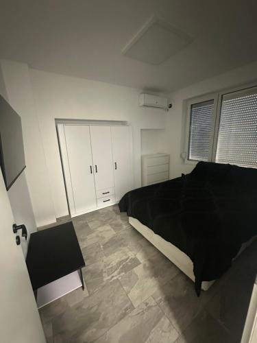 1 dormitorio con cama negra y armarios blancos en Best places, en Petrich