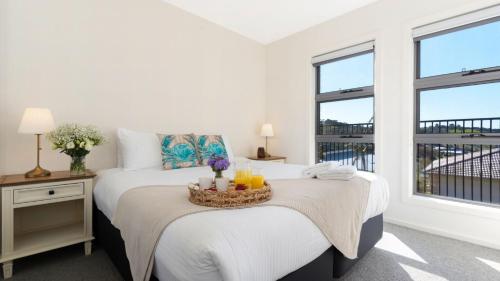 a bedroom with a bed with a tray of drinks on it at Summit to Sea in Kiama