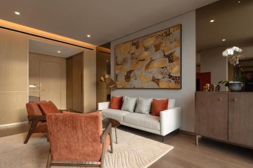 a living room with a couch and a table and chairs at SOMA HOTEL Riverside in Phnom Penh