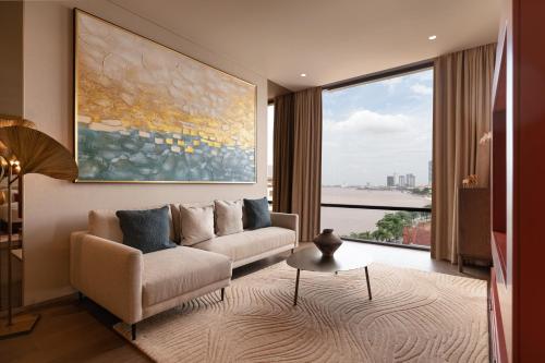 a living room with a couch and a large window at SOMA HOTEL Riverside in Phnom Penh